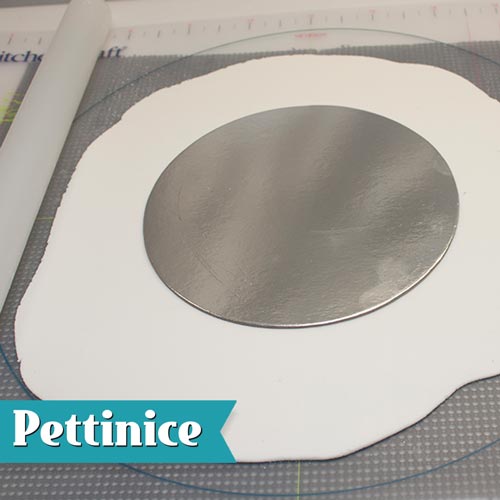 Roll out  Pettinice larger than the size of the presentation board. Place a board the same size as your cake in the centre.
