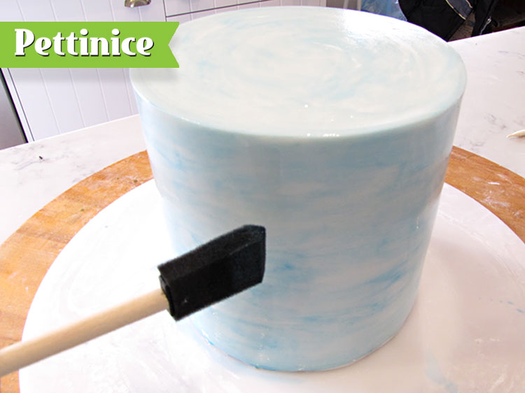 For the top white tier use a sponge or a wide soft brush and brush a little blue food colour mixed with rose spirit or alcohol or lemon extract around the cake to give a watercolour effect look.