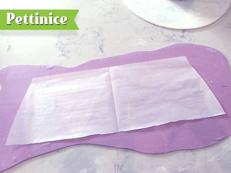 For the top tier, cut a piece of baking paper into the shape you would like for the ‘corset’ piece to go around your cake and then use this as a guide to cut the correct size piece of fondant.