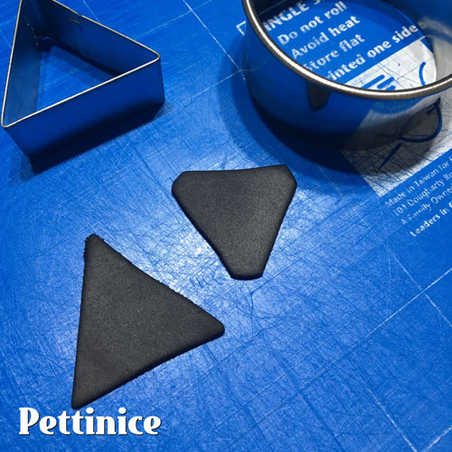 Roll out some thin Black Pettinice, get a triangle cutter and a circle cutter, round the edges of your triangles and place them on ALL the corners of the Amp.