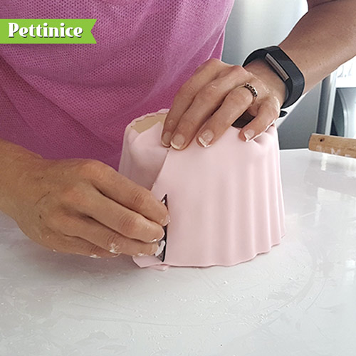 Once fondant is wrapped around do a rough trim on top to cut away the excess.