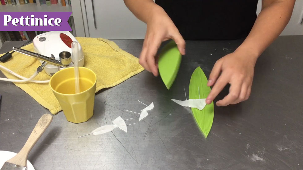 Create texture by pressing damp wafer fins between leaf embosser.