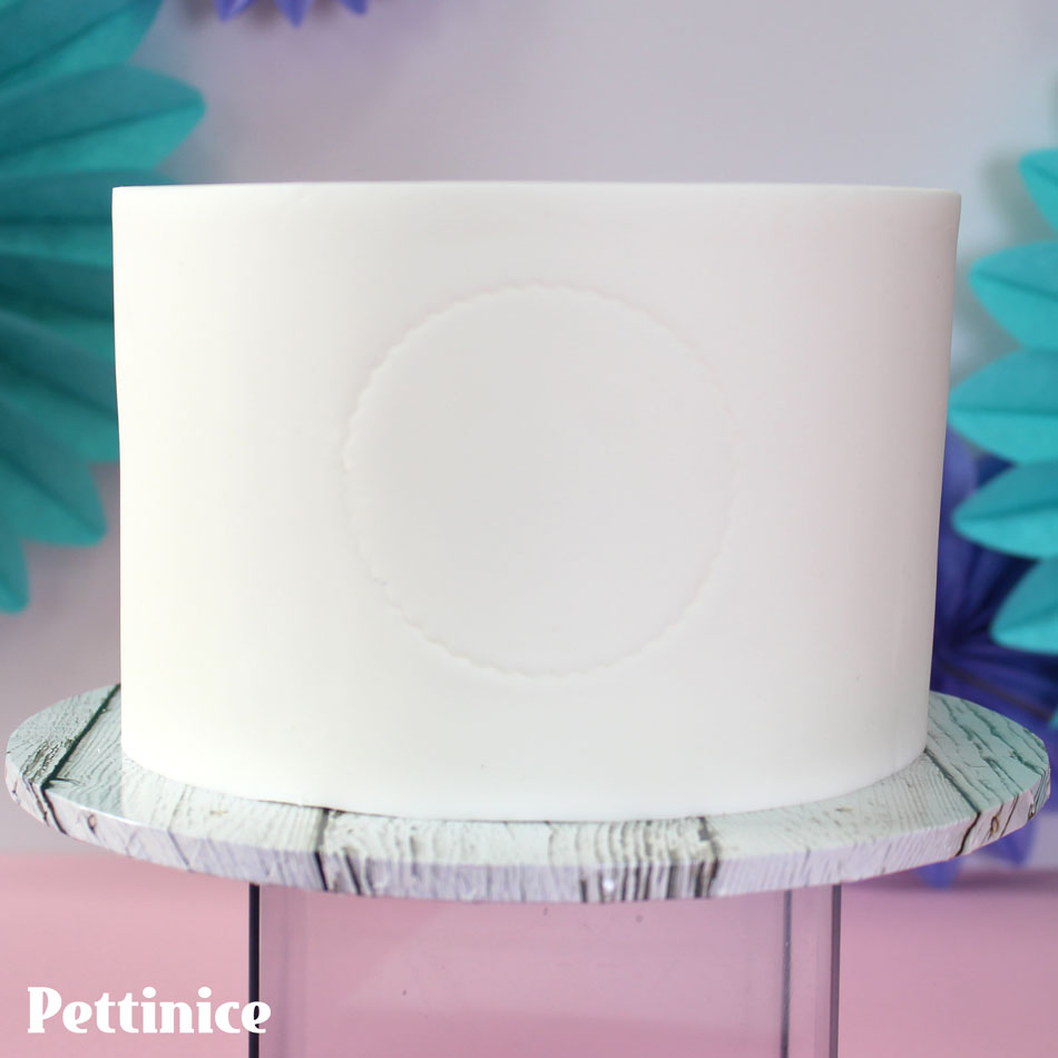 Cover your cake with Pettinice fondant and use a circle cutter to mark your frame as a guide..