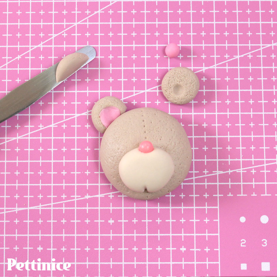 Use your toothpick to create a little dent in the snout. Texture the ears and roll a small pink ball to flatten inside the ears.  Cut the ends and stick to the head with a little bit of water.