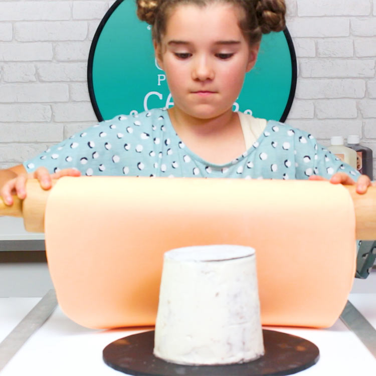 Remove the cake from the fridge and if it's not sticky to the touch, spray a little water or rub with vegetable fat so the fondant will stick to it.