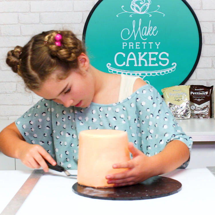 You could remove the fondant at the top, but we decided not to.  Nudge your cake to the edge so you can slip your spatula under the cake....