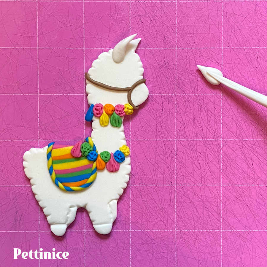 For the other ear, make a wee tear drop shape and press the quilting tool on the centre to make it more ear shaped, pinch at the base, and stick to the llama just behind the cut out ear.