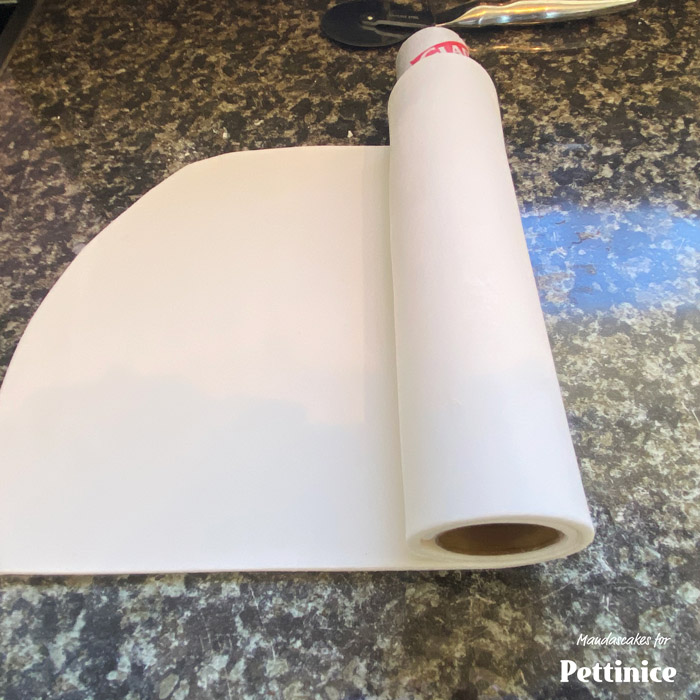 Lightly dust the sheet with potato starch or cornflour. Using a card board tube (NOT an toilet roll), something sturdy like a glad wrap tube is perfect, roll the sheet around the tube keeping the straight edge flush with the edge of the tube.