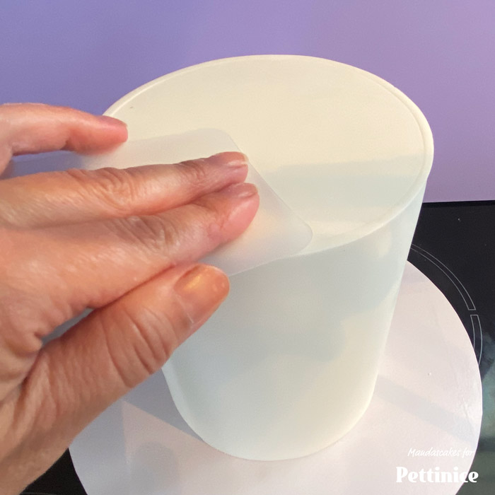 Put a cake board on the base of the cake and flip it back to being right side up. There will be a seam, which you can smooth out a bit more using a smoother or flexi smoother.