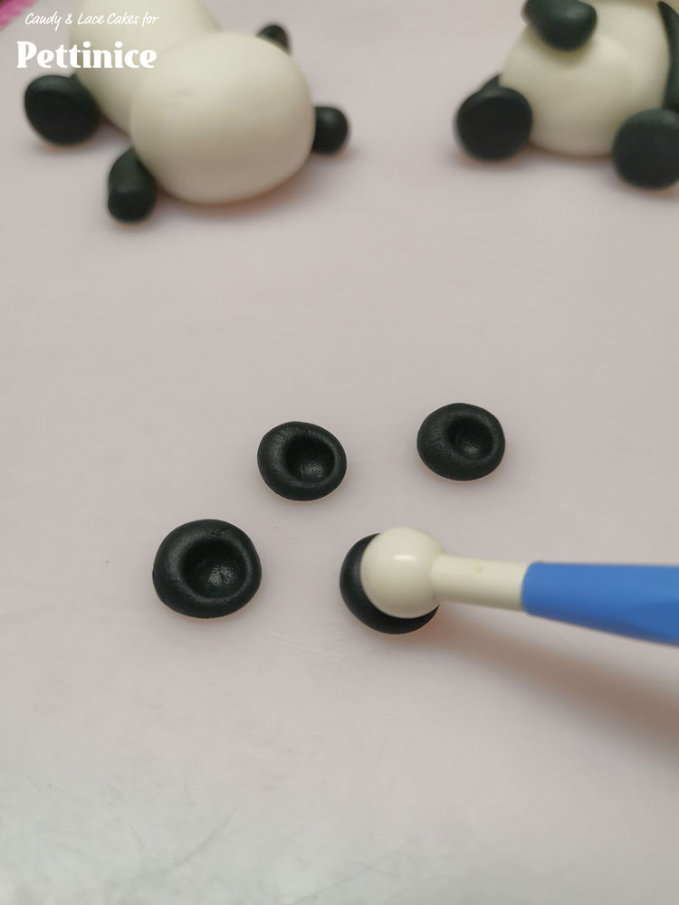 Roll 4 small black balls for panda's ears and make indents with your ball tool. Attach to the tops of their heads.