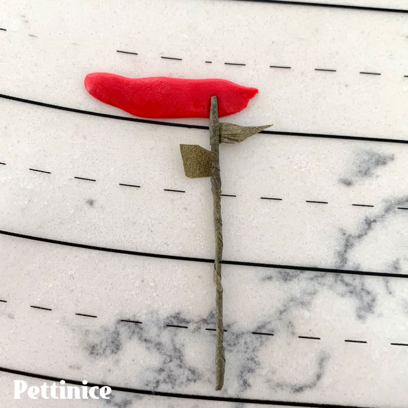 39. I made a very simple rolled rose with covered floral wire and a small strip of red Pettinice. The leaves are cut from florist tape. You can use a stick of thin spaghetti for the stem if preferred and to keep everything entirely edible.
