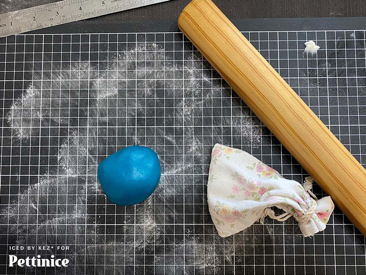 Grab the colour that you are covering the top of your cake with.  Roll it out onto a surface lightly dusted with cornflour.