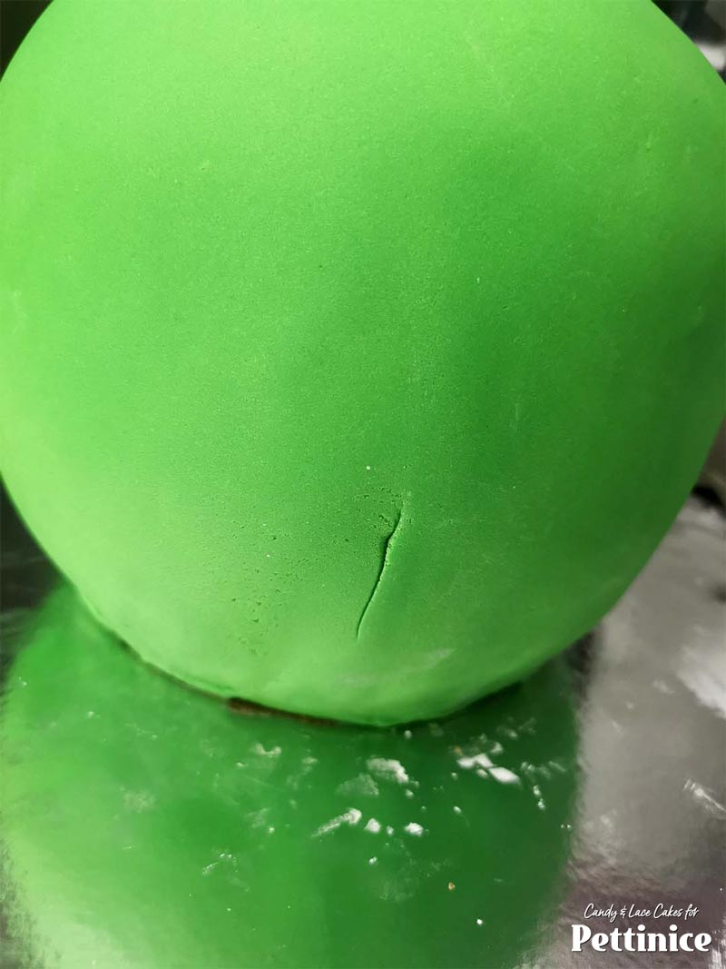 Once the fondant has been smoothed around the entire cake, trim the edges around the bottom.