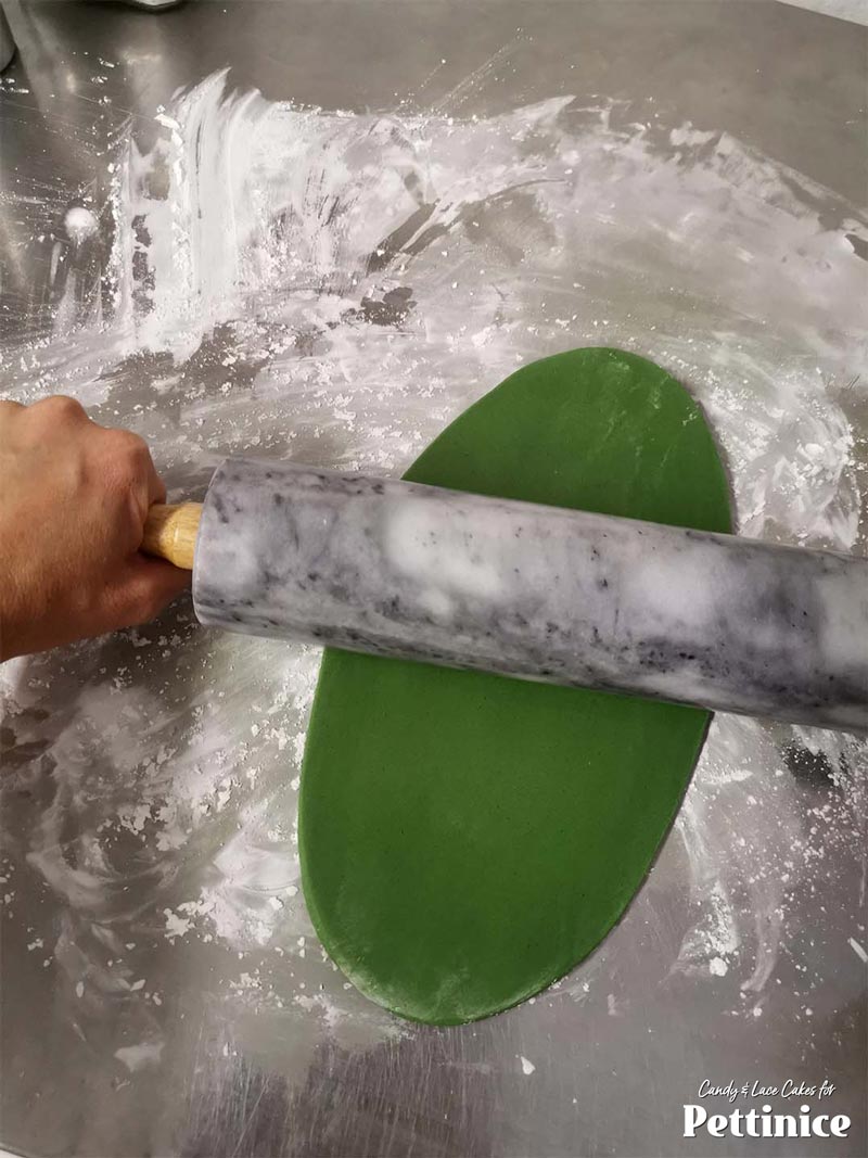 Roll your deep green nice and thin and cut out strips to apply to your melon cake.