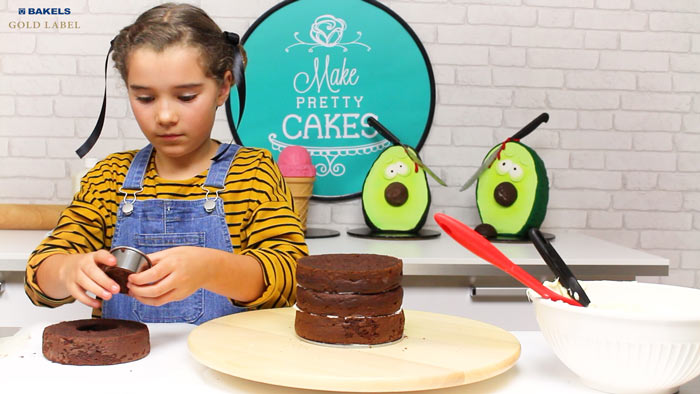 Use your circle cookie cutter and cut a hole in the top layer of your cake.