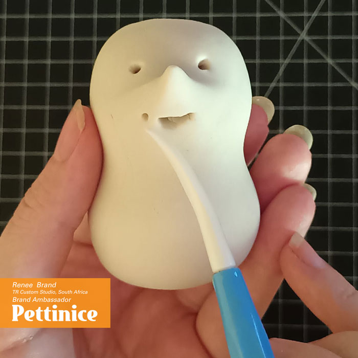 Using the thin side of your Dresden tool, put the tip in the mouth and gently push outwards stopping by the small hole creating his smile. (Repeat this step on both sides of the mouth).